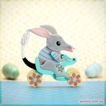 Stunning brooch of a Bilby riding a toy bike in beautiful pastel tones
