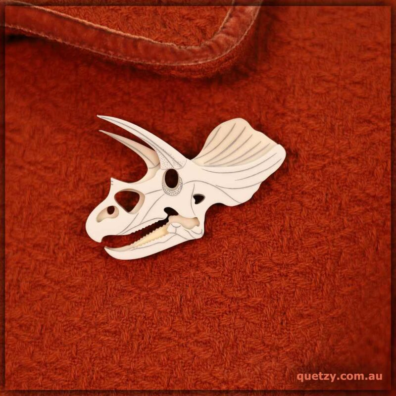 Triceratops fossil skull brooch representing a real-life fossil. Designed and handmade by Quetzy