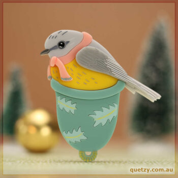 An Eastern Yellow Robin nesting in an upturned bell. Acrylic brooch designed and handmade by Quetzy